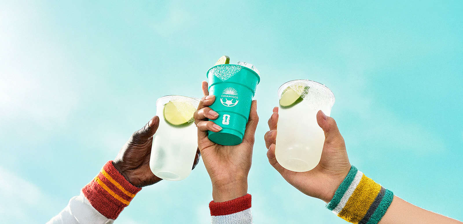 Three hands raising Casamigos margarita cups in a toast during FIFA World Cup 26™ celebration