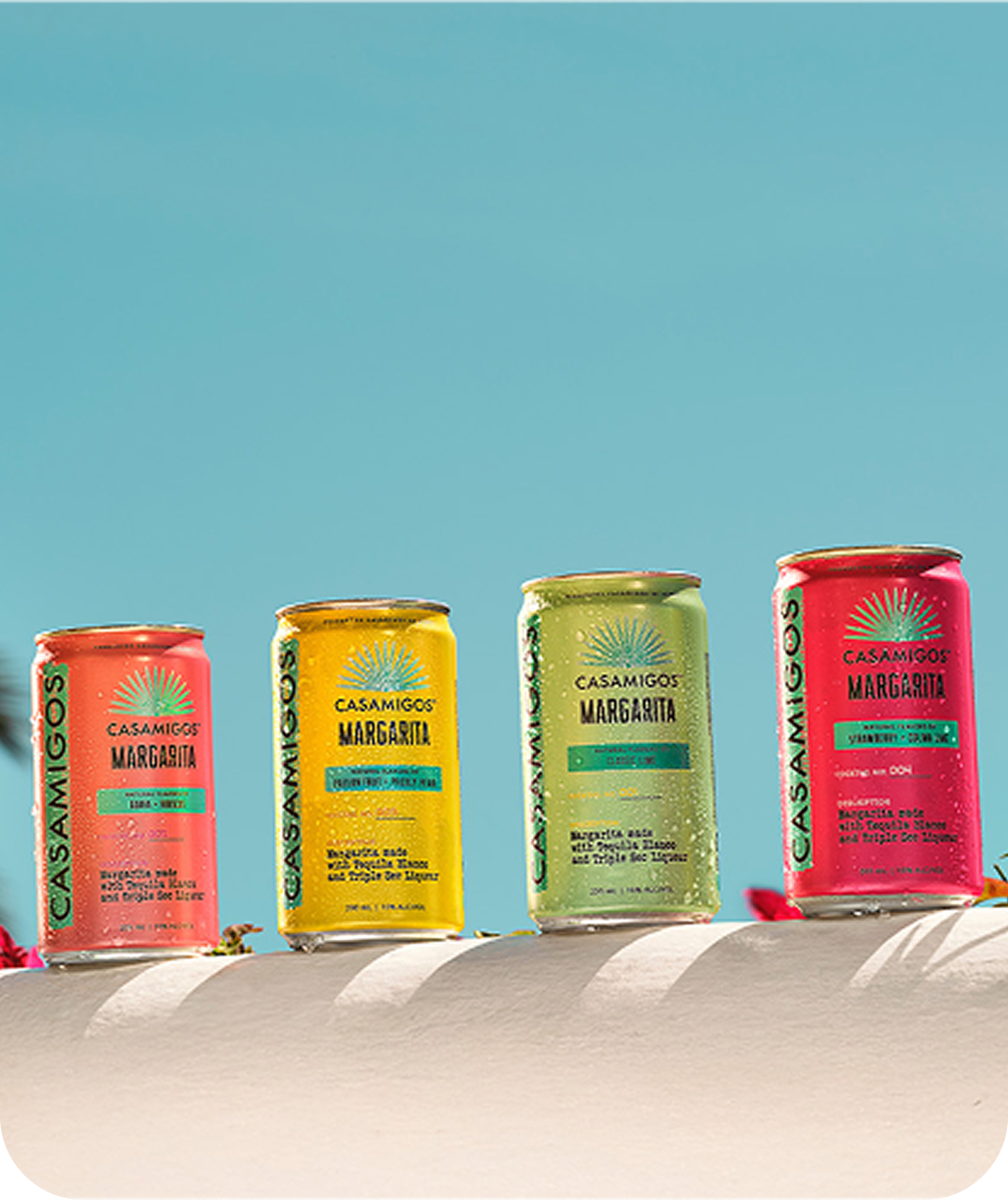 Casamigos Ready to Drink Margarita on a ledge surrounded by pink flowers.