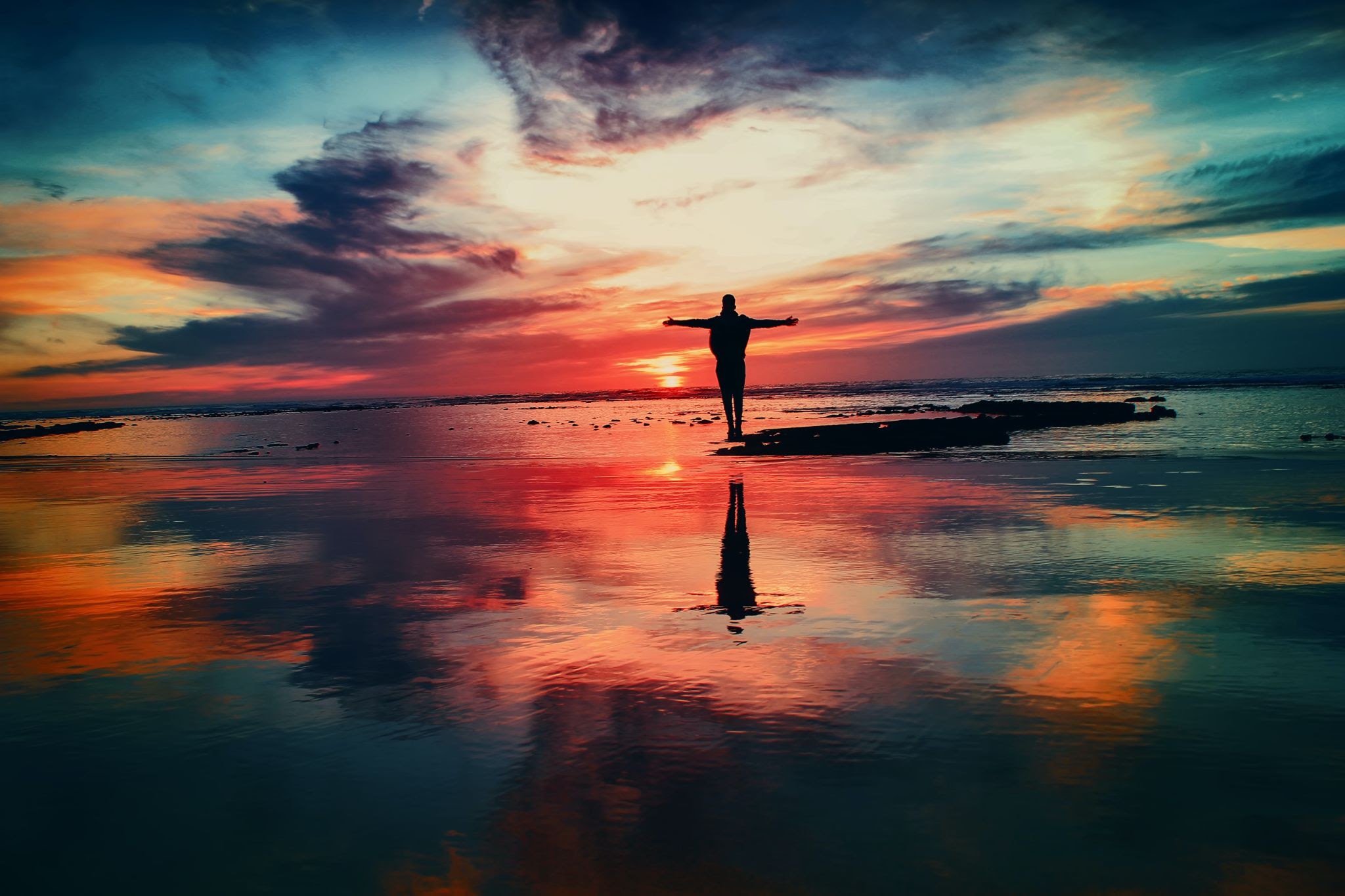 Person taking in a sunset at the beach