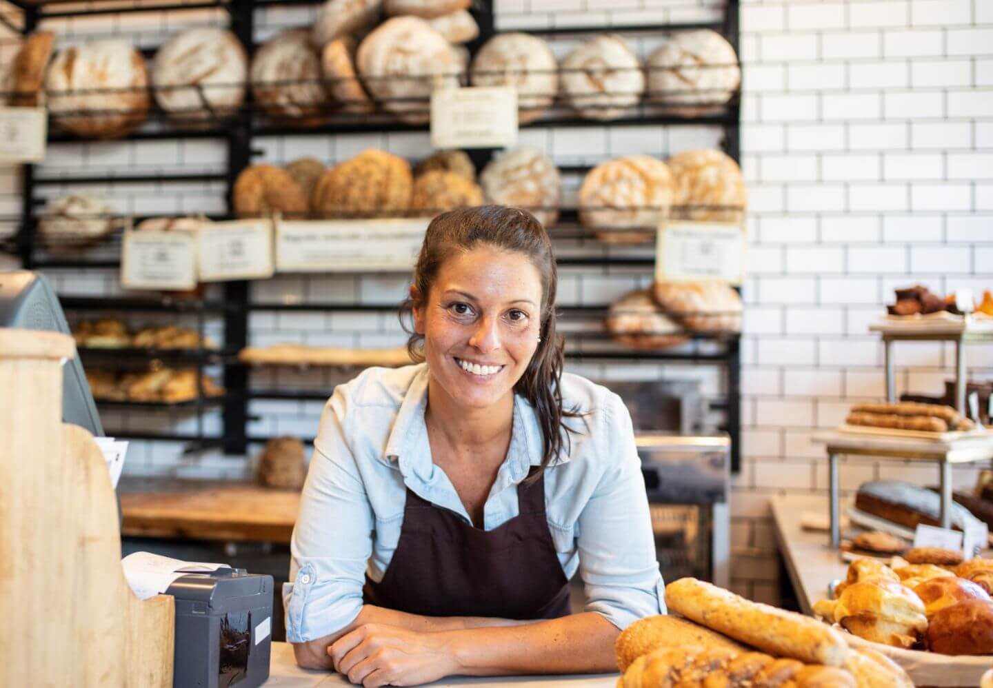 A bakery owner smiles confidently in her recently upgraded shop.