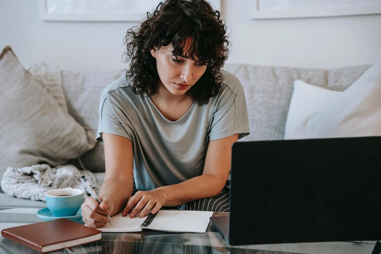 Woman on computer taking notes on life and disability insurance.