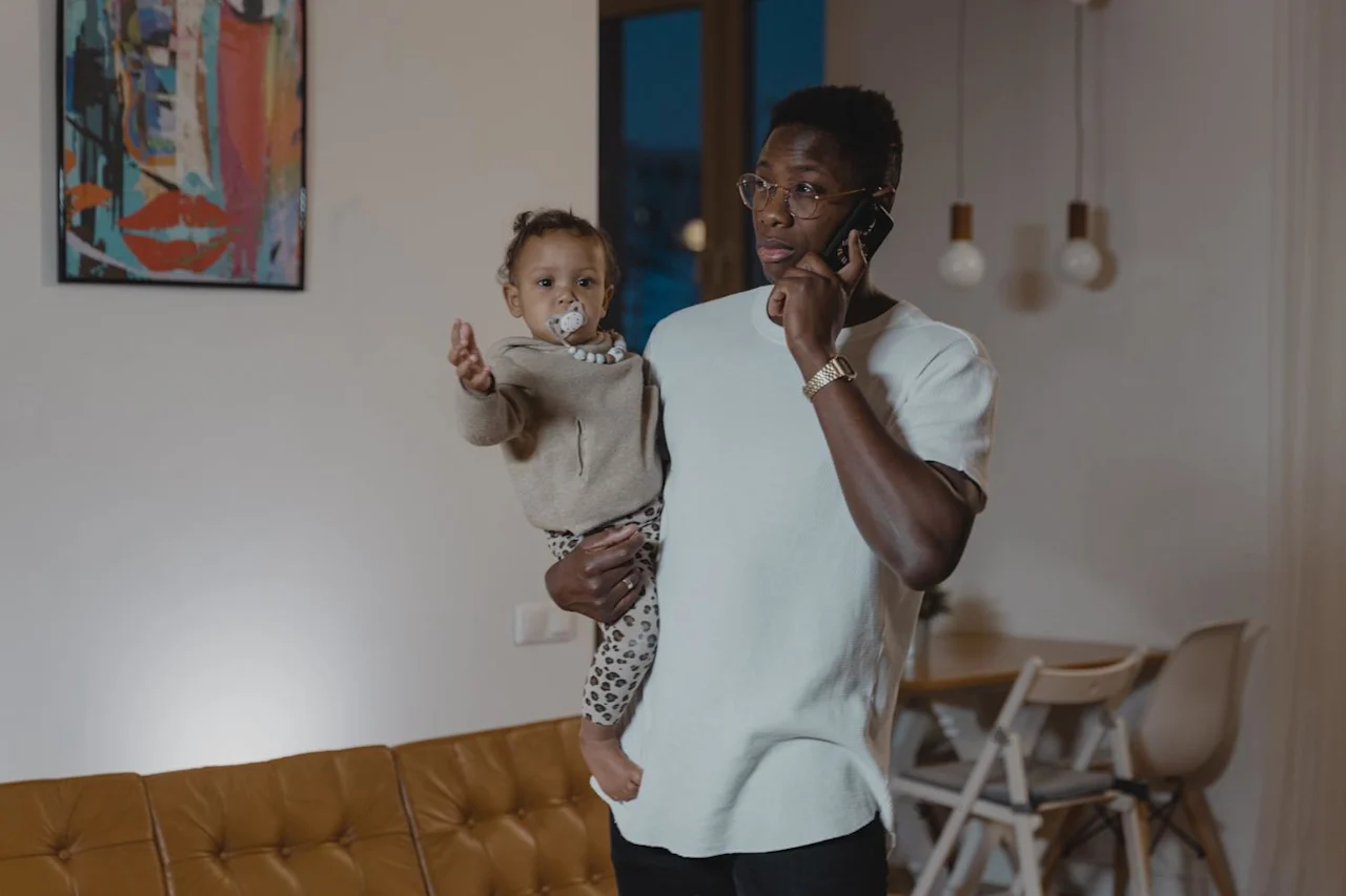 Man with his kid talking on phone about estate planning vs financial planning.