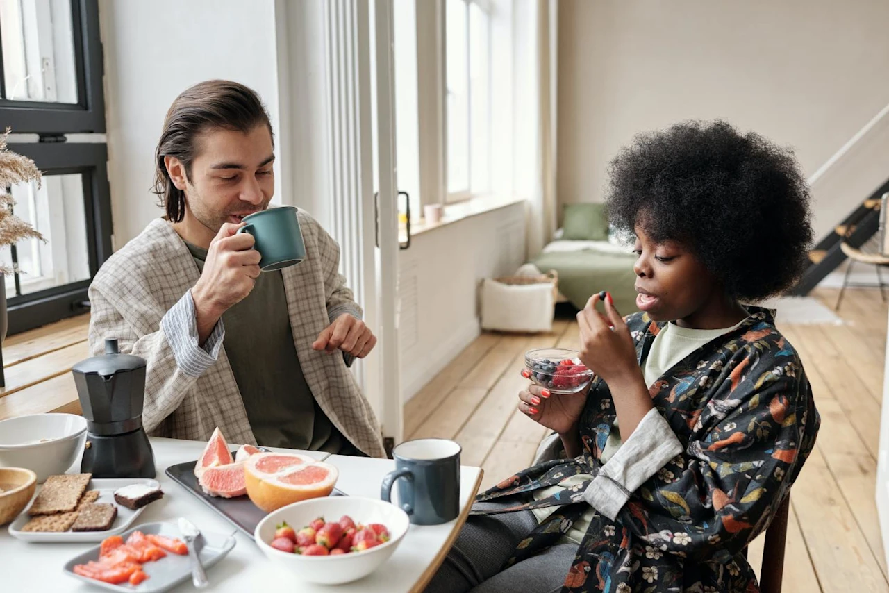 Couple drinking coffee and talking about retirement savings by age.