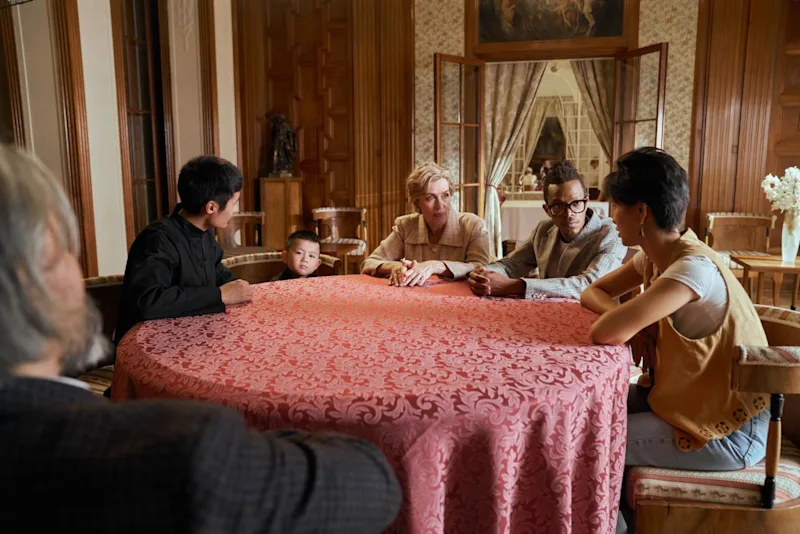 Family sitting around a table for the reading of the Will.