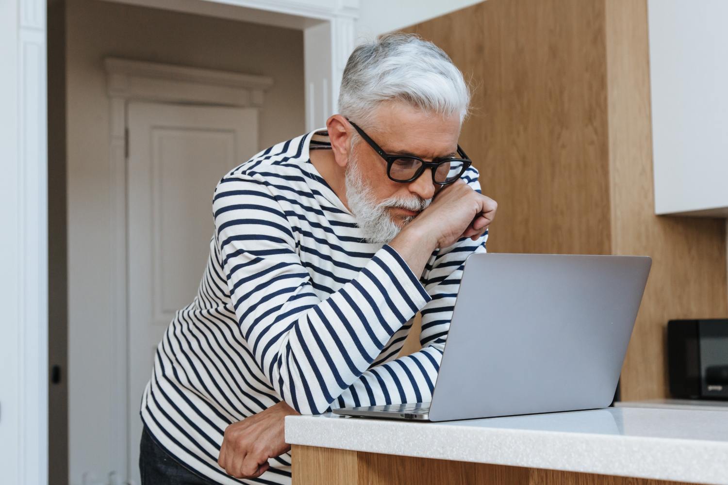 Man on laptop researching reverse mortgage after death and estate planning.
