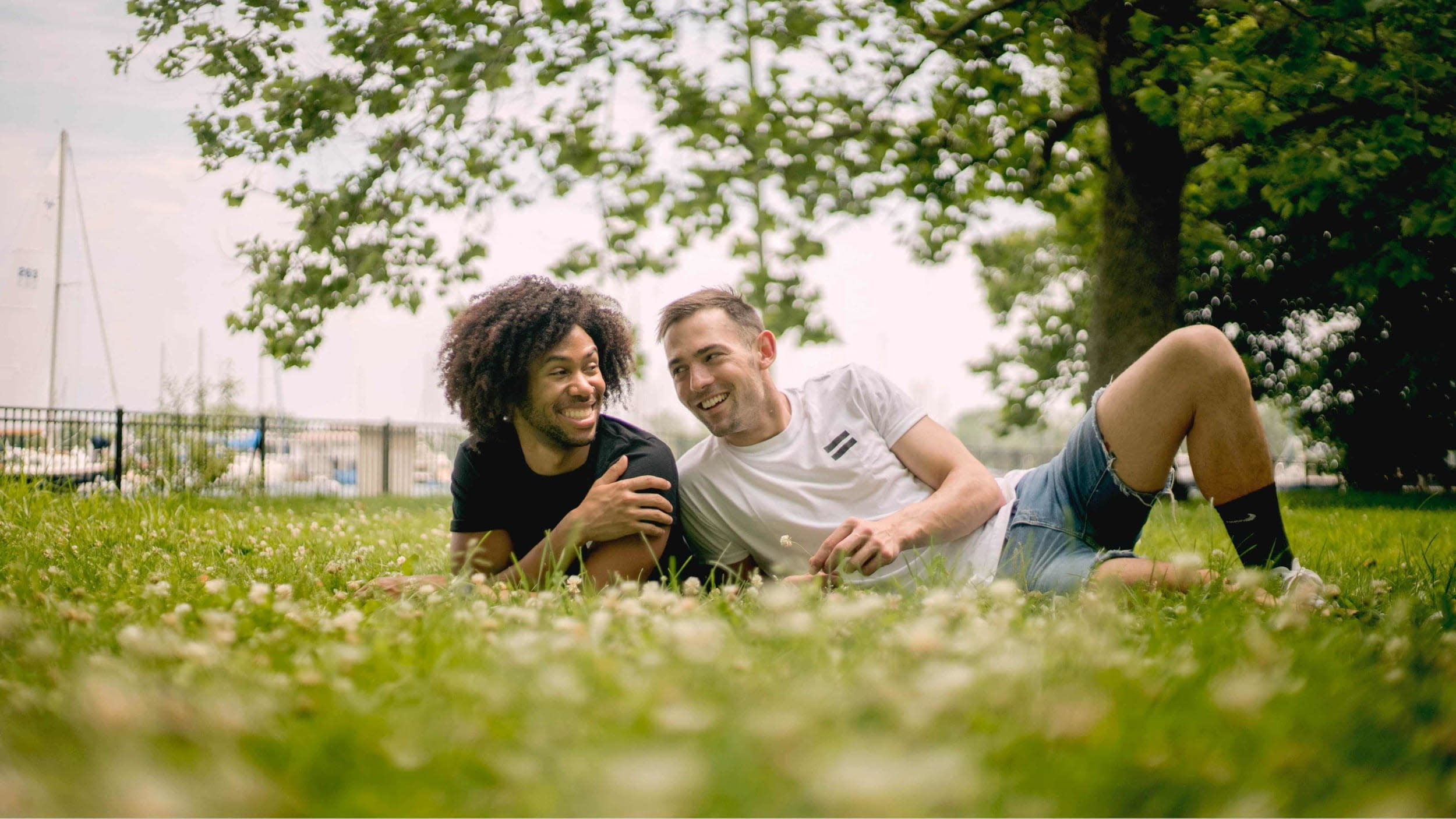 two men laughing sitting on grass