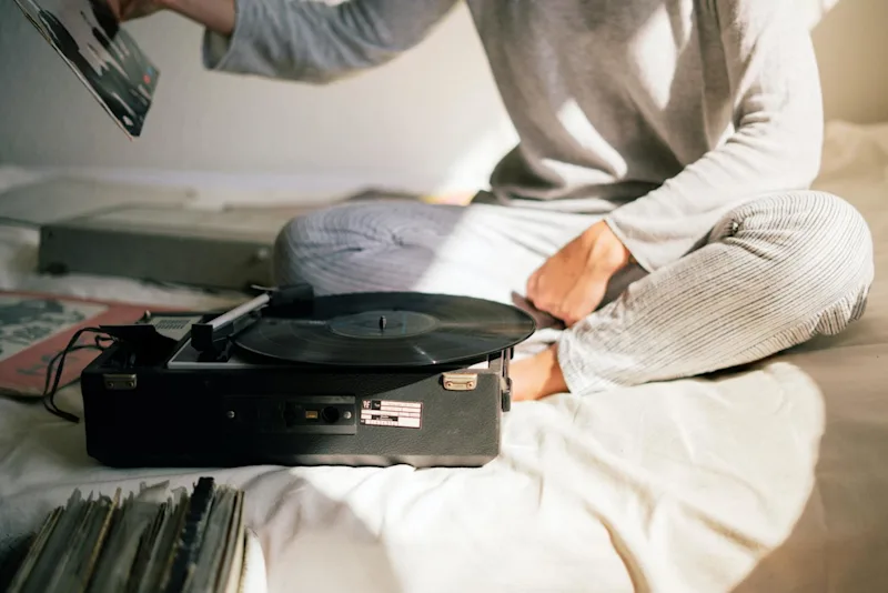 Woman listening to Elvis records after learning about the Elvis Presley estate battle.