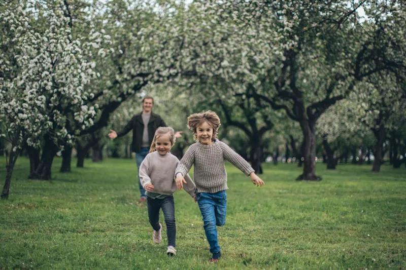 Man playing outside with daughters after learning how ancillary probate works in California.