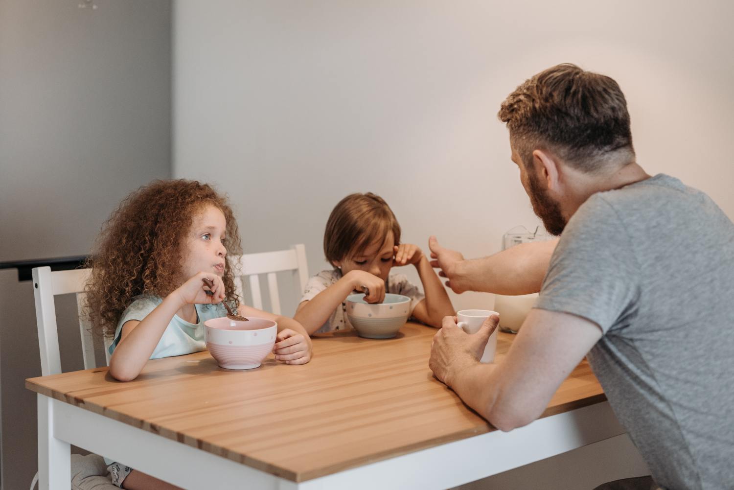 Dad with kids eating breakfast in house inherited with a reverse mortgage.