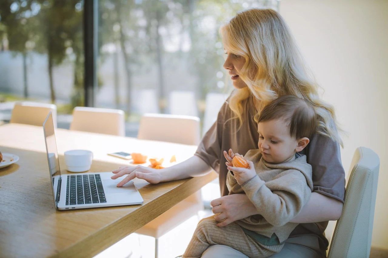 Mother holding her child while researching the steps to probate a will.