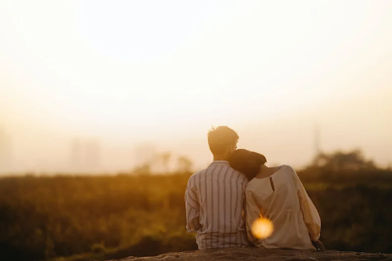 Couple looking at the sunset mourning a loss. 