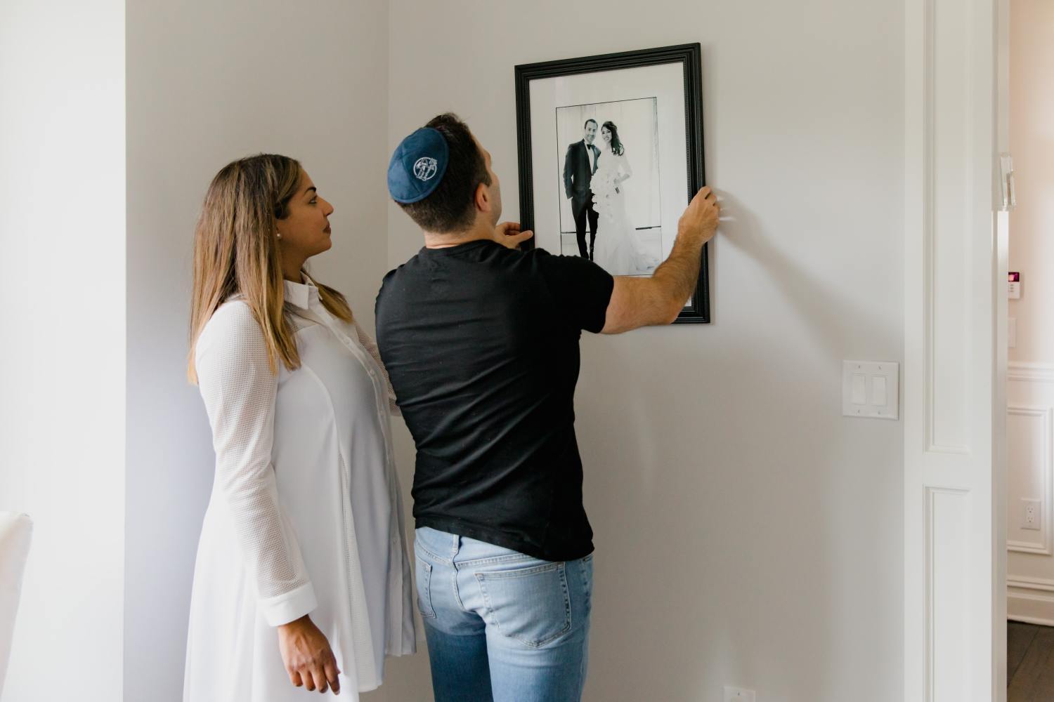 Couple hanging up frame after deciding to create a living will.