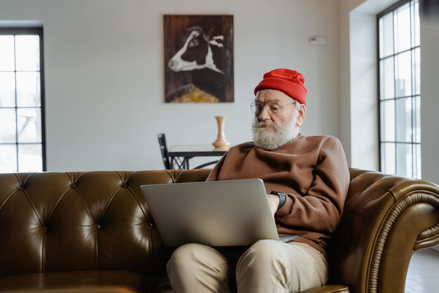 Man on couch researching guide to reverse mortgage occupancy requirements.