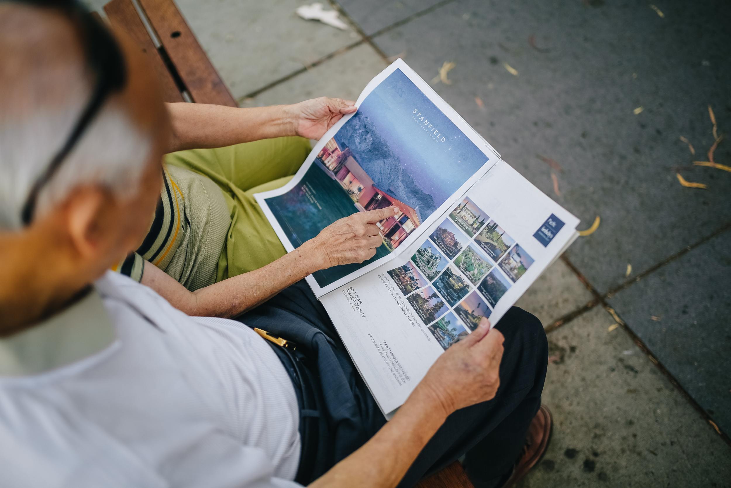 Older couple flipping through travel brochure after planning ahead for retirement.