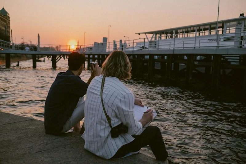 Two men sitting by the water and talking about creating a Living Trust in California.