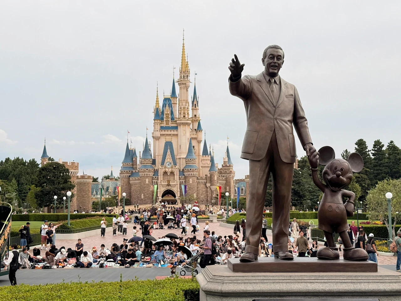 Partners statue of Walt Disney holding Mickey Mouse's hand in front of Cinderella Castle at Disneyland