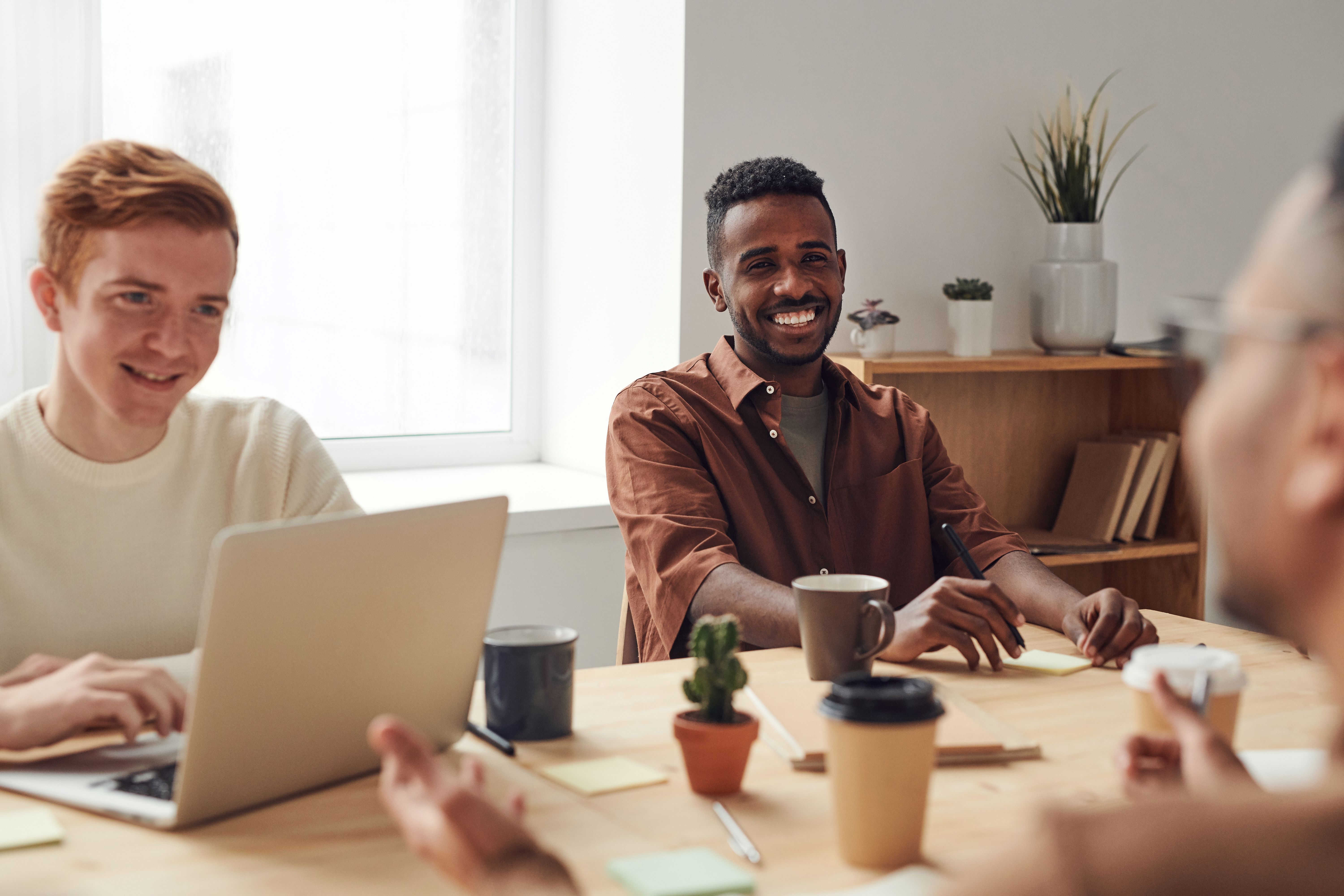 This image shows a group of creative professionals collaborating happily around a work table