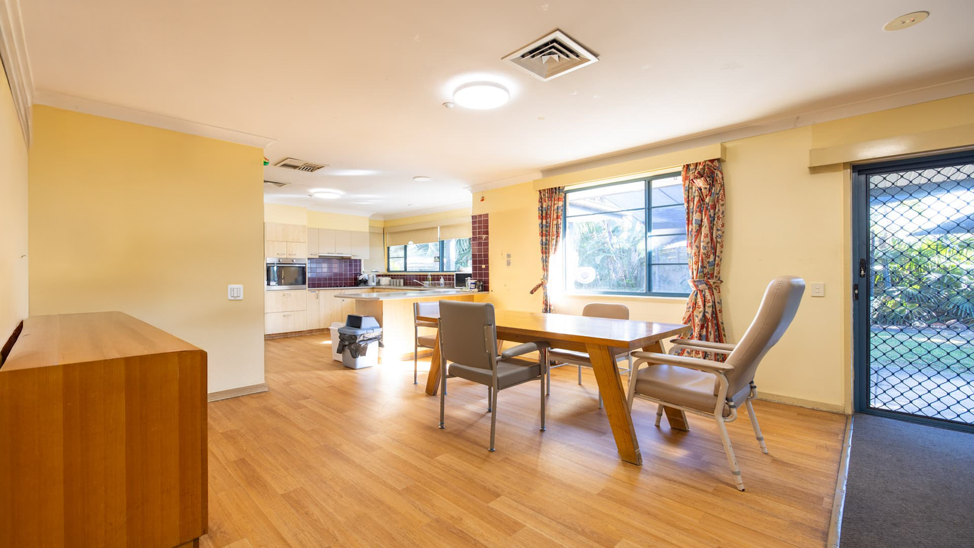 Open plan dining room on hard wood flooring, overlooking kitchen.