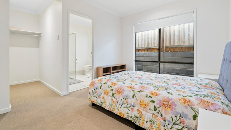 Master bedroom with double bed, ceiling fan, walk-in wardrobe and access to a private ensuite.