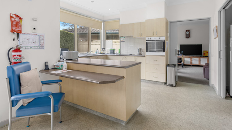 Modern, open kitchen with light wood cabinetry, accessible workspace, and built-in oven