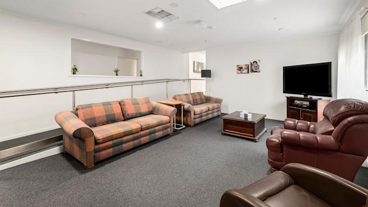 Loungeroom with two couches and two armchairs.