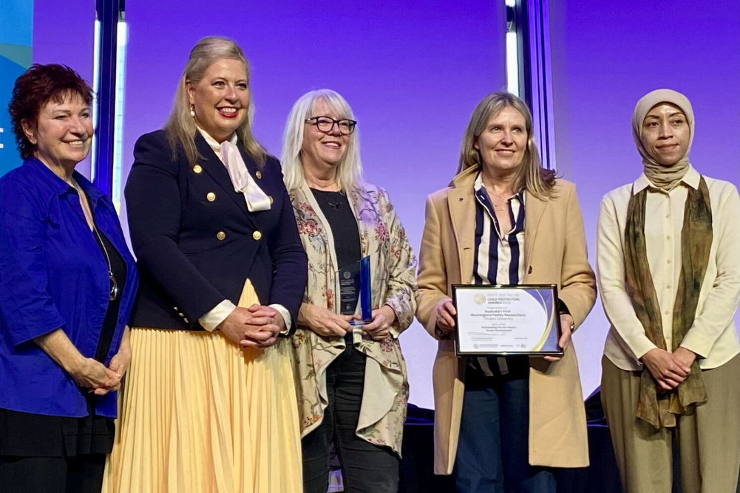 Katrine Hildyard MP and Melissa Gibson, Child and Family Focus SA, on stage awarding the Outstanding Service - Sector Development to Flinders University staff.