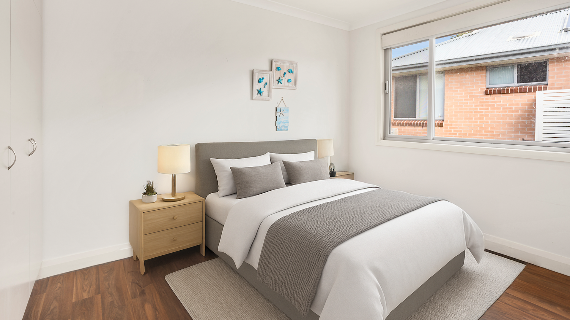 bedroom with wooden floorboards, a two door wardrobe and a small framed painting on the wall.--