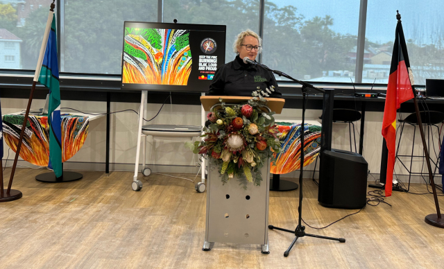 Paula Head speaks to the audience from behind a podium