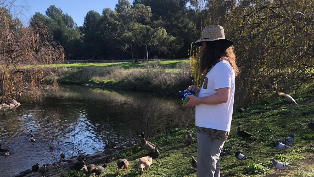 Kenny pictured at a park in South Australia feeding ducks.
