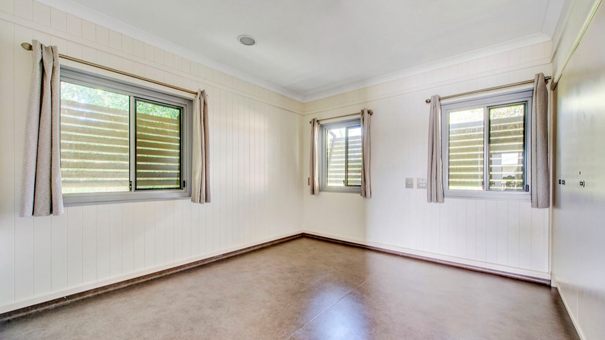 --Large open bedroom with wooden floors, BIR and windows.--