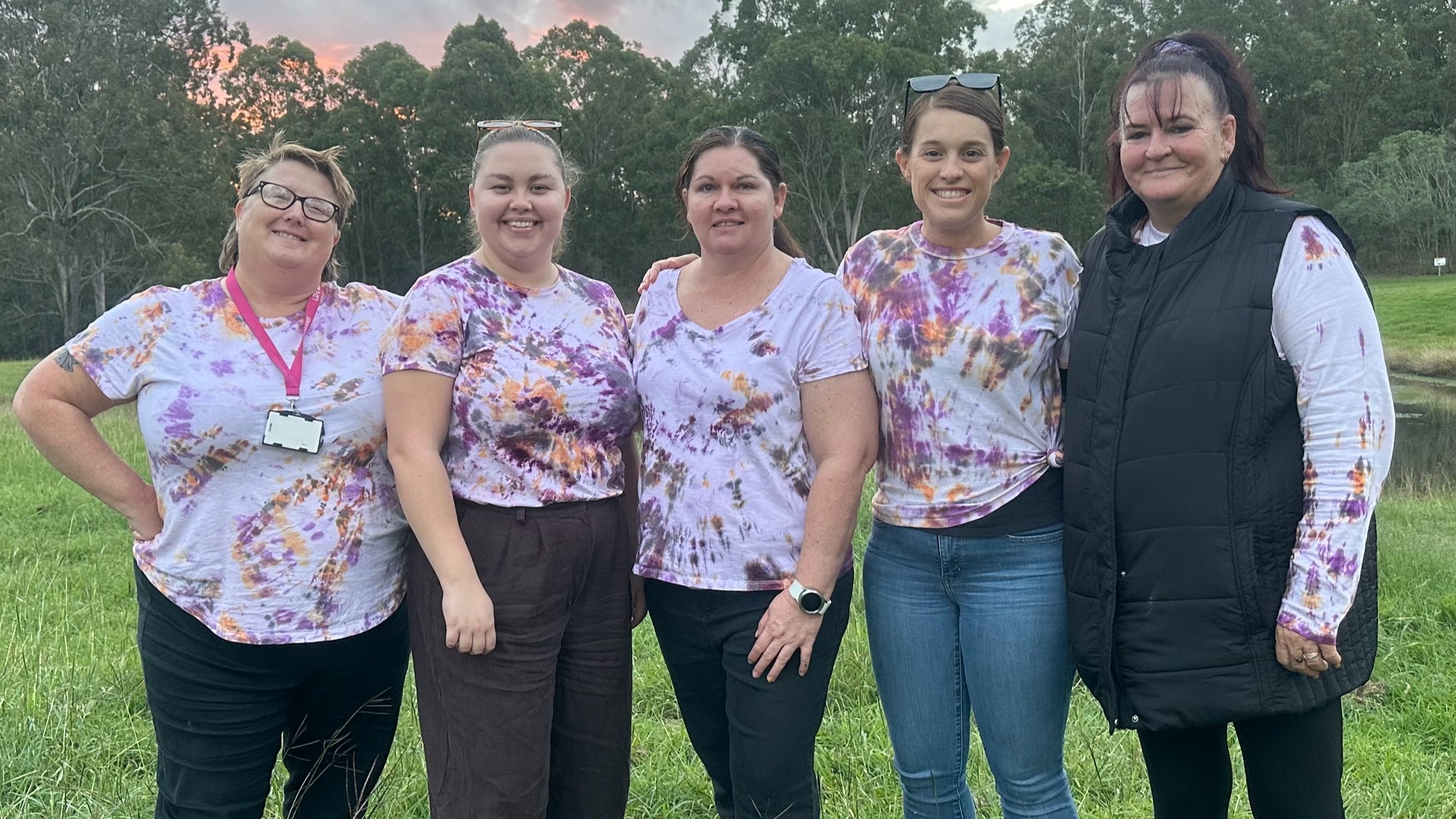 Four staff members outdoors, smiling at the camera.