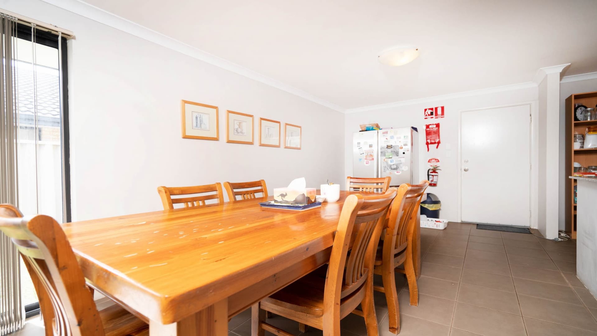--Dining area with a large wooden table with six seats.--