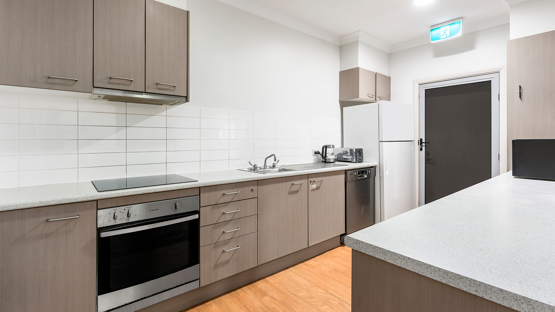 galley kitchen with glass door leading to the rear patio.