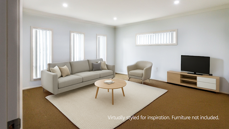Neutral-toned living room with a light grey sofa, matching armchair, wooden coffee table, flat-screen TV on a low cabinet, and multiple vertical windows allowing natural light.