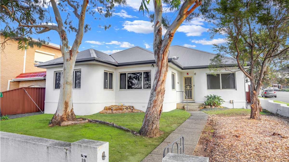 Concrete pathway to main front entrance of charming white painted house.  There are four steps up to the front door, with handrail.