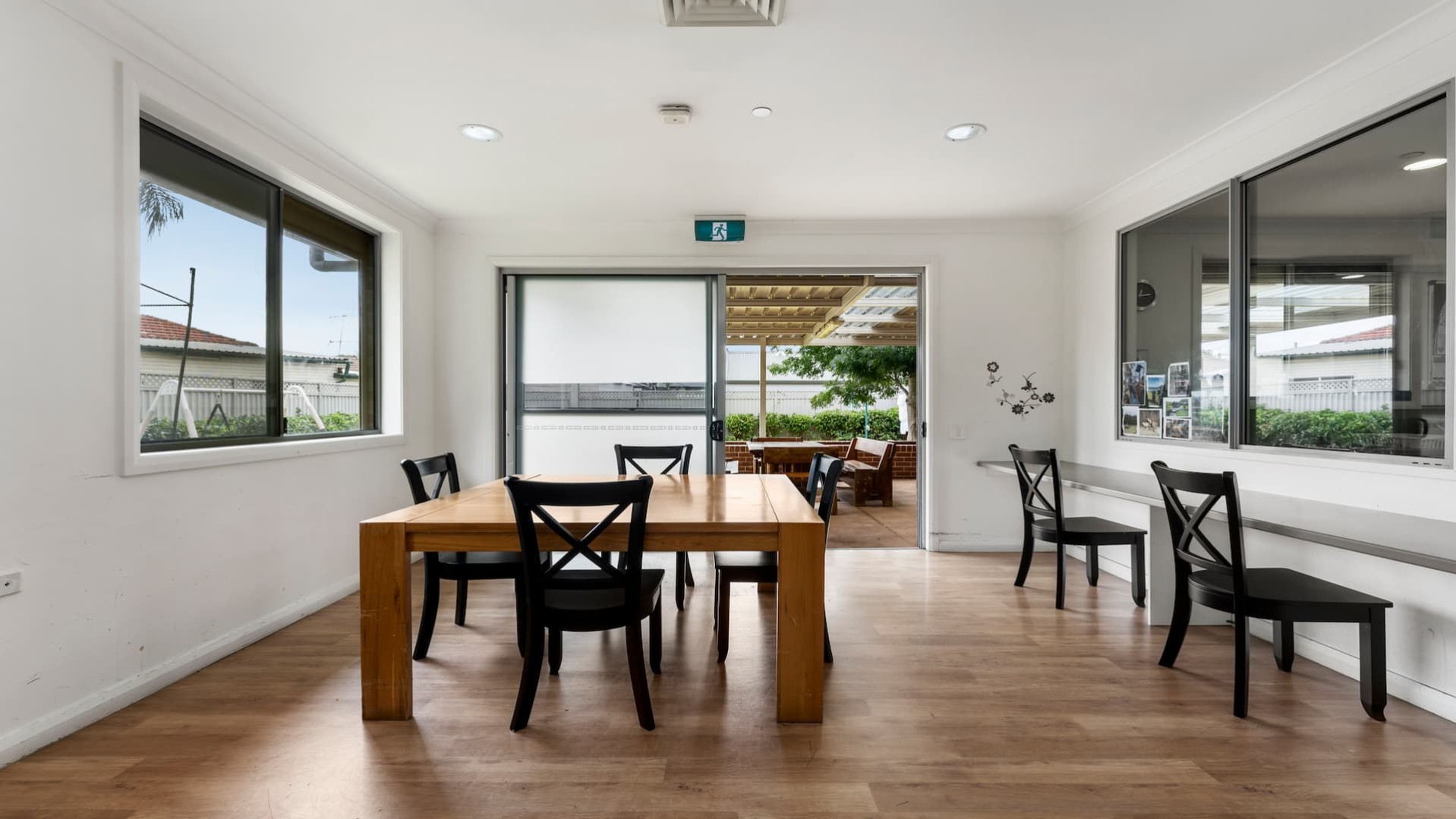 Dining area with a wooden table and chairs, and a bench running the length of the wall to the right.