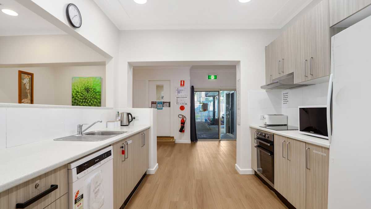 Open plan kitchen with oven, stovetop, microwave and dishwasher.