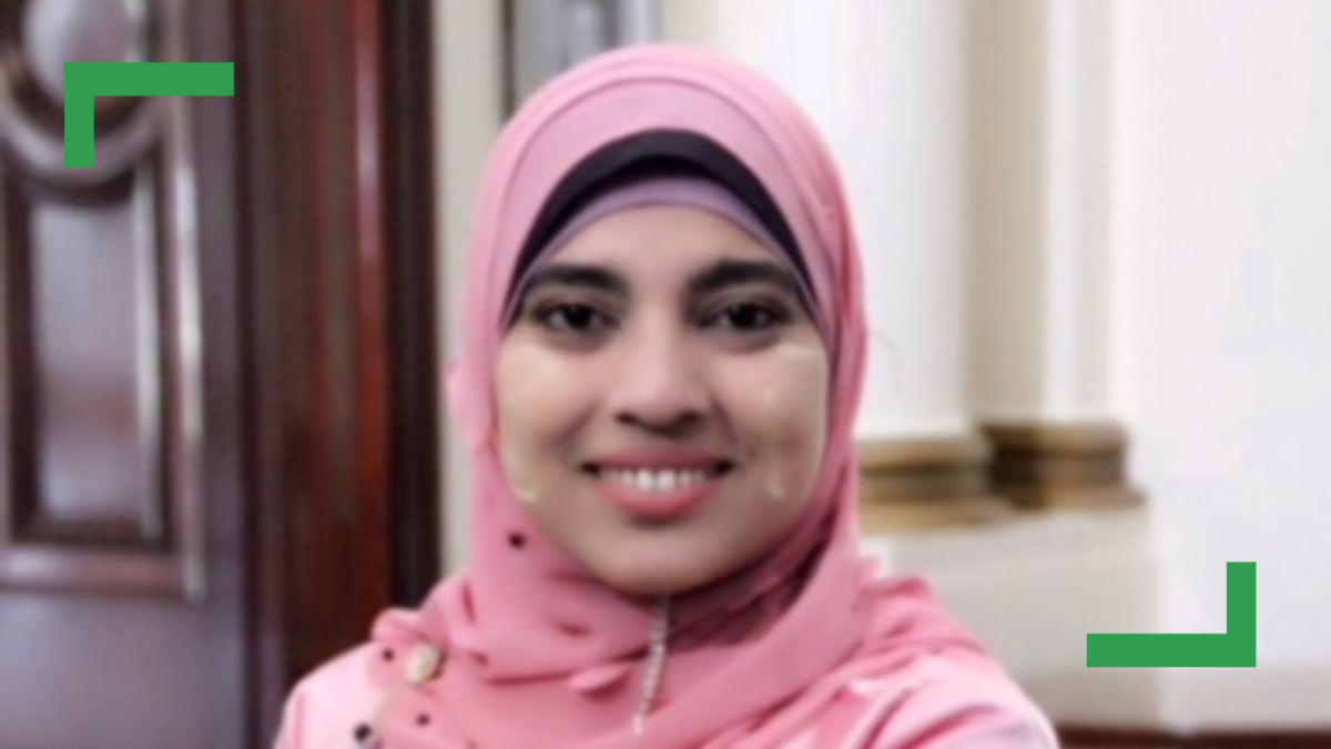 Close up of Jumabhi in a pink hijab smiling at the camera