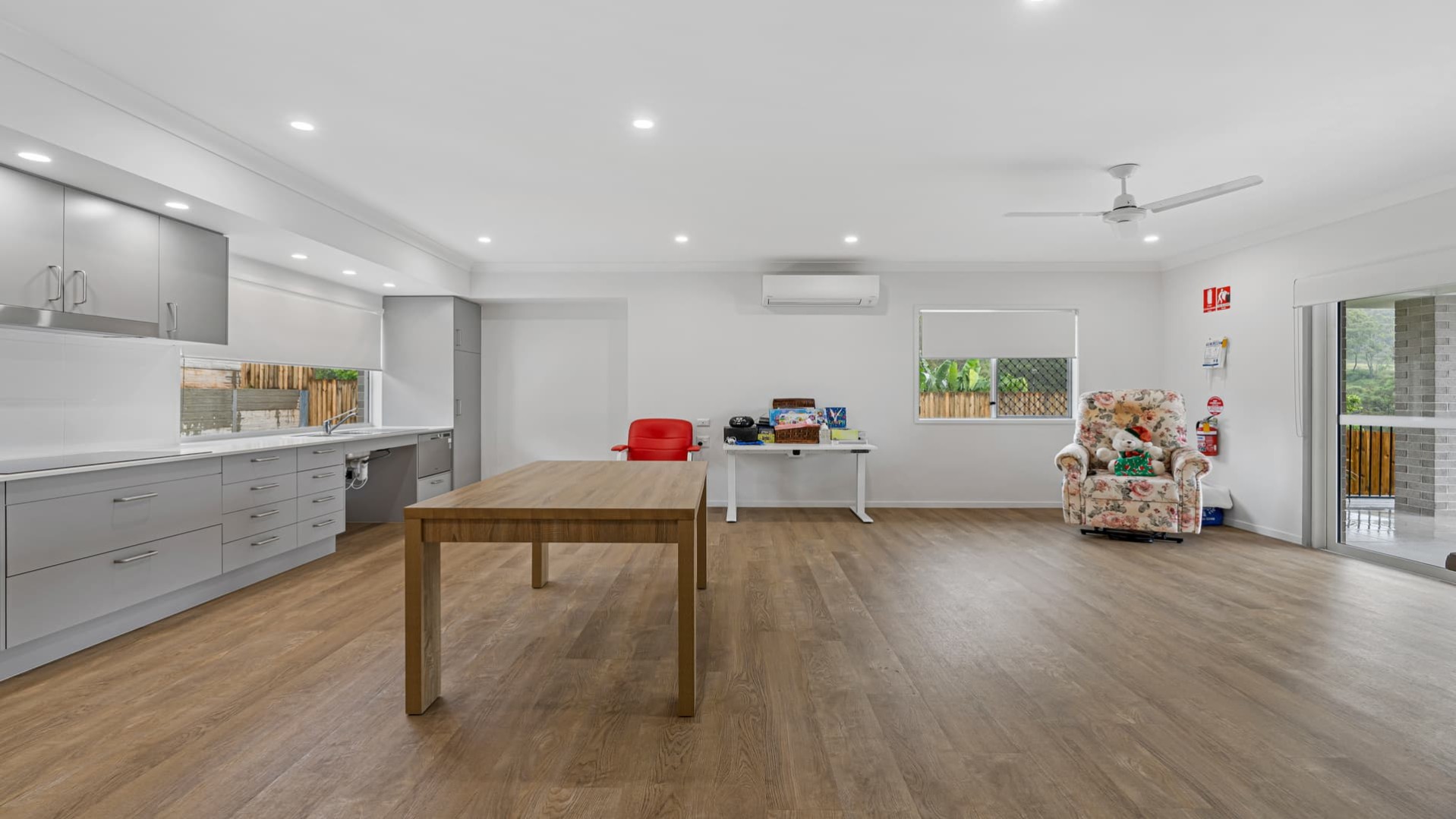 Open plan kitchen along one wall, overlooking the dining, combined living space with window and sliding door to access rear yard.