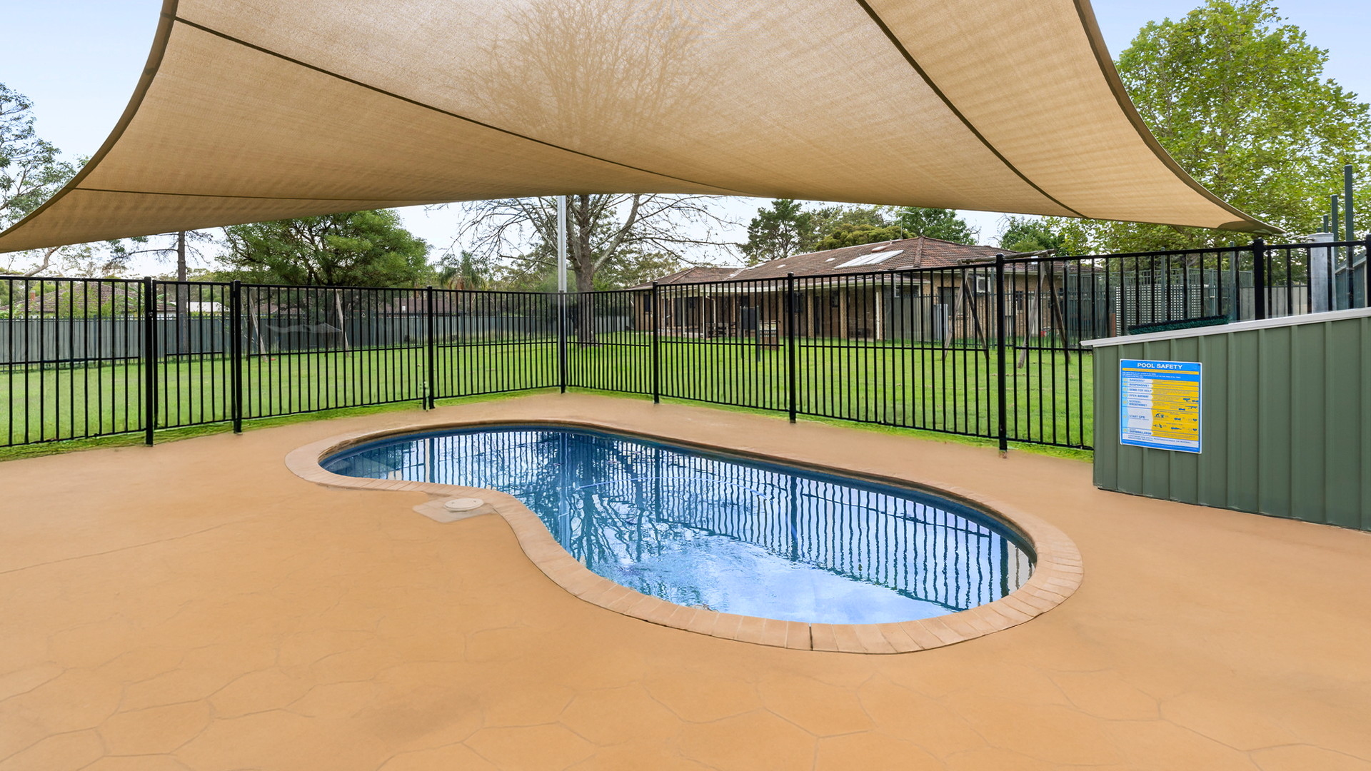 Swimming cool with a shade sail over the top, surrounded by fencing.