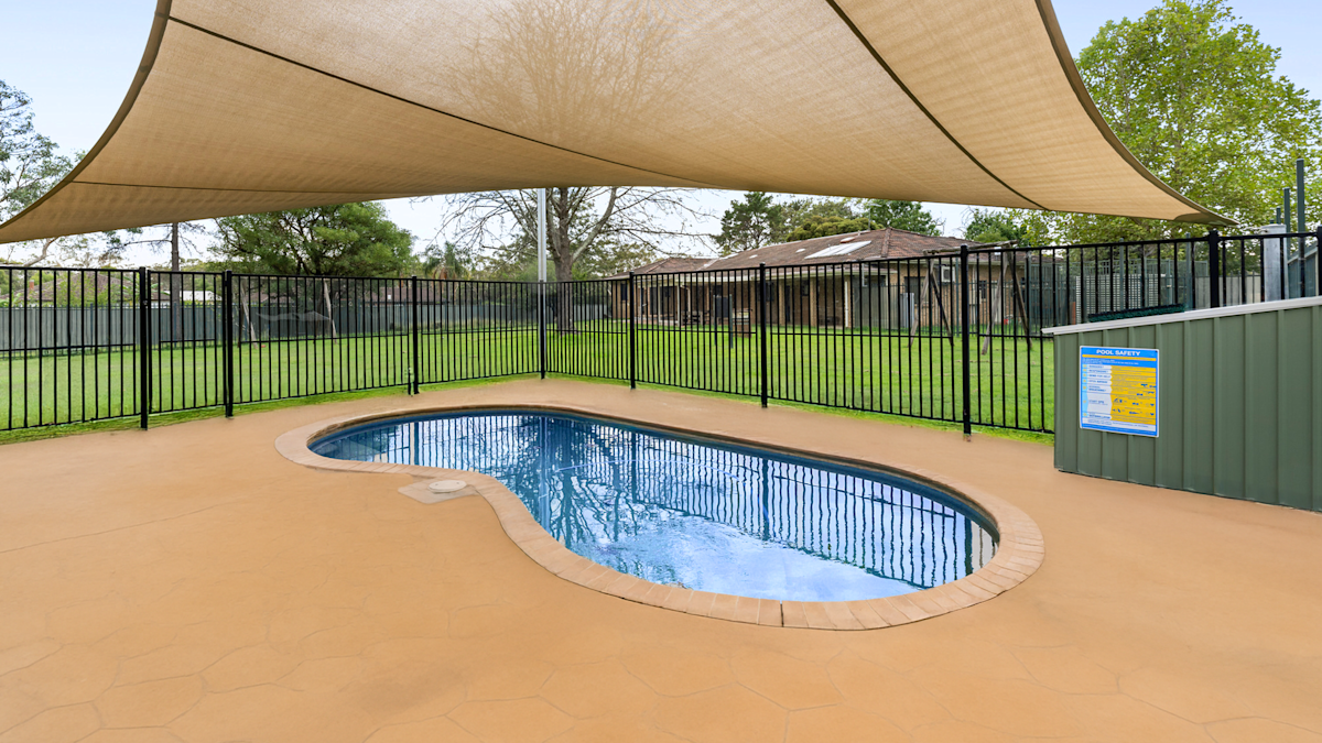 Swimming cool with a shade sail over the top, surrounded by fencing.