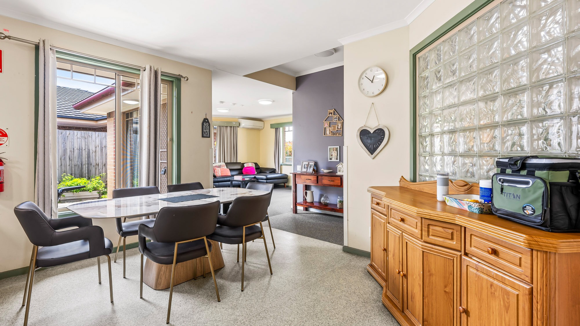 Open-plan dining and living area with table, seating and natural light.