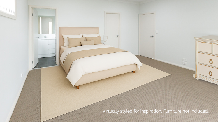 Spacious bedroom with beige carpet, a large bed with cream and tan bedding, white walls, and a dresser in the corner near three doors and an ensuite bathroom.