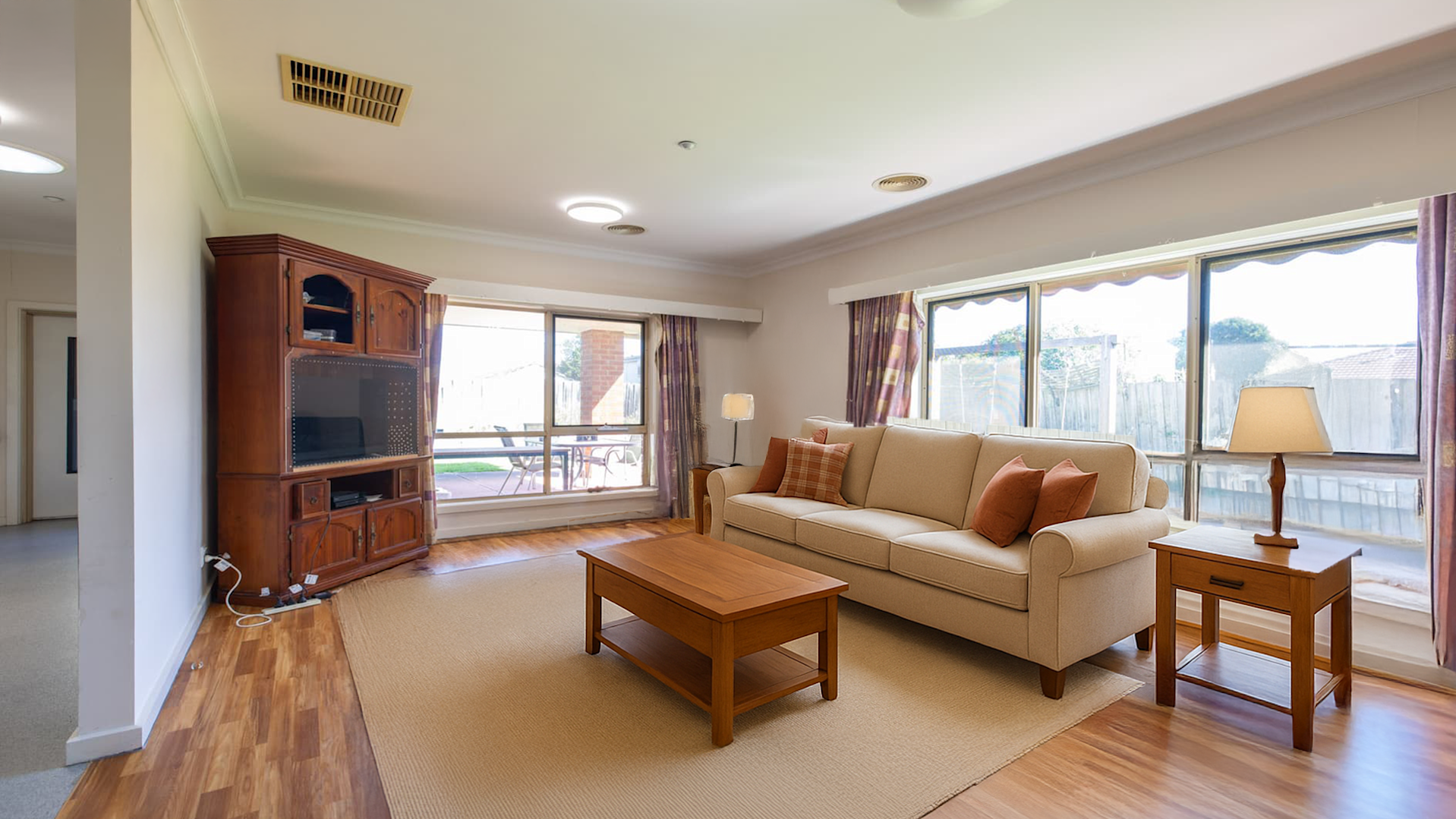 Loungeroom with leather sofas facing large windows and a television