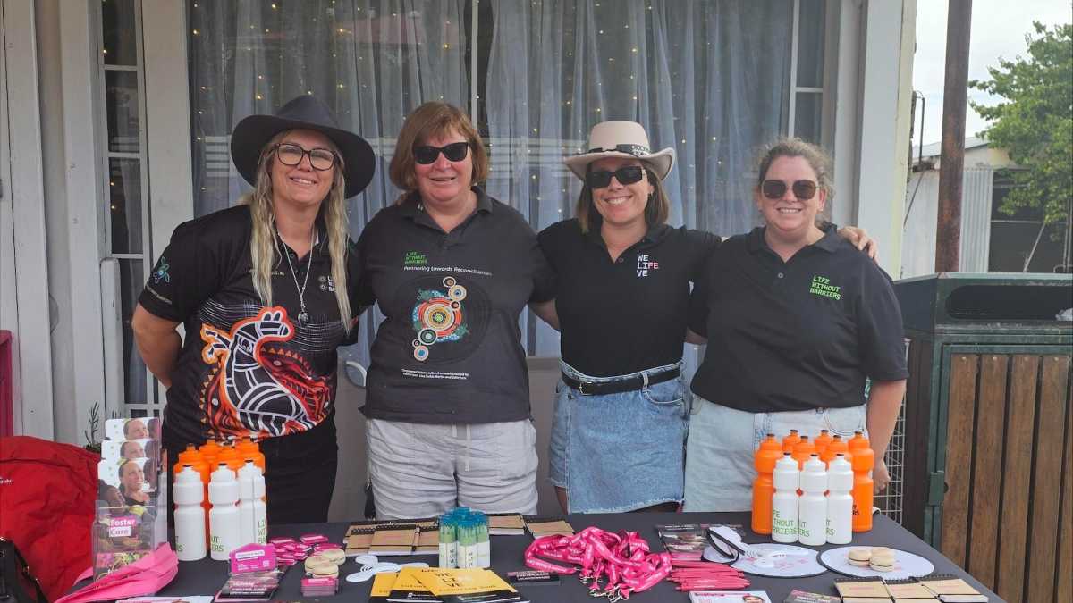 Four staff members at the Life Without Barriers stall at Wanarayimanha National Reconciliation Week Walk.