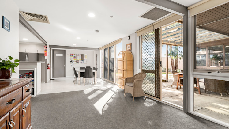 ---Carpeted area leading towards the kitchen and dining area.--