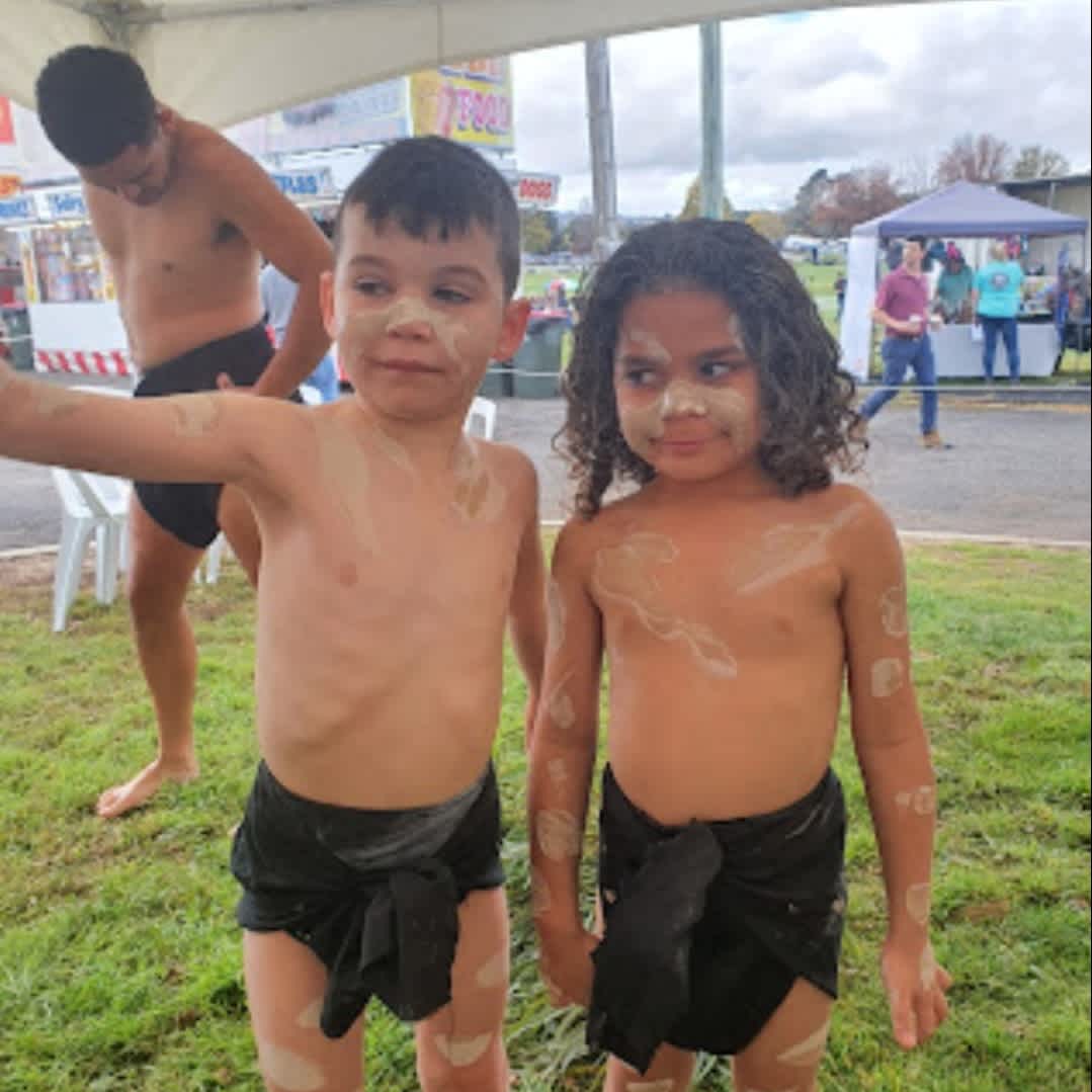 Benji and Tjirra, two young Aboriginal dancers from Dinanwans Connection dance group standing together wearing white body and face paint.