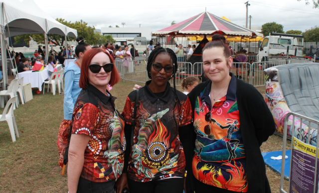 A group of staff smile at the camera at the TAIHS NAIDOC event.