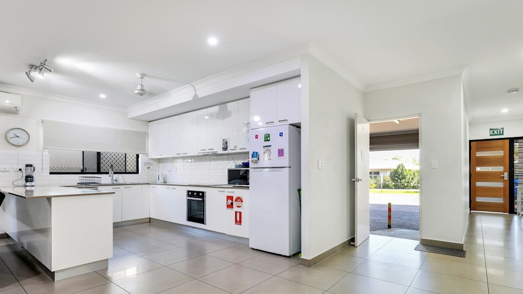 --Large wrap around kitchen with tiled floor and white fixtures.--