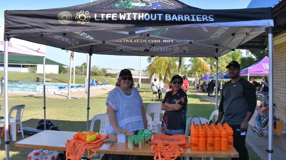 Life Without Barriers Marquee with staff standing behind a table set up with bags, water bottles and balls.